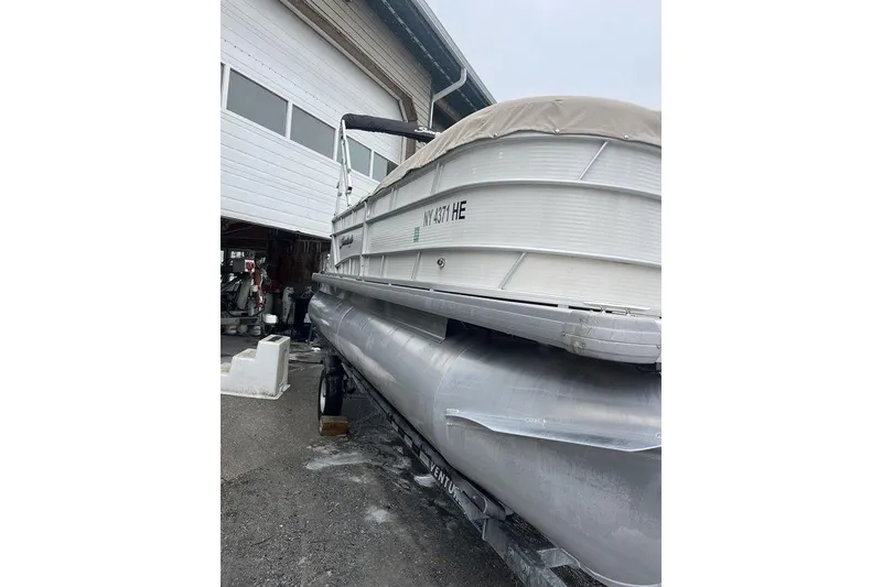 Slide: The Image of 2016 Godfrey 2086 pontoon boat parked outside a garage. - 6
