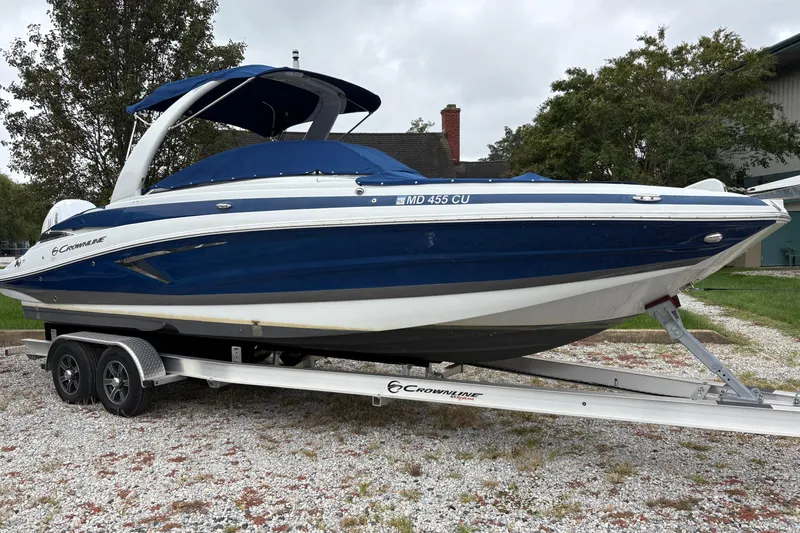 The Image of 2022 Crownline Eclipse E285 XS boat on trailer, parked outdoors. - 0