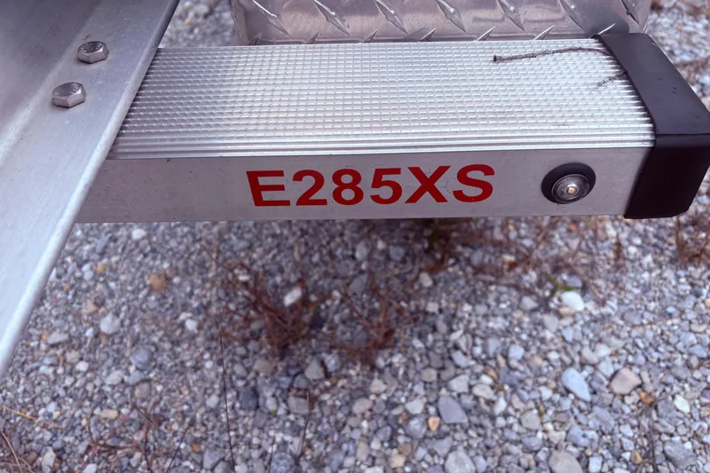 Slide: The Image of 2022 Crownline Eclipse E285 XS boat trailer detail on gravel surface. - 14