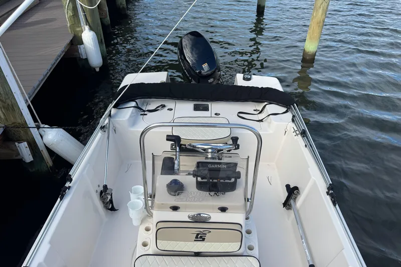 Slide: The Image of 2023 Carolina Skiff 16 JVX CC boat docked, featuring console and motor. - 11