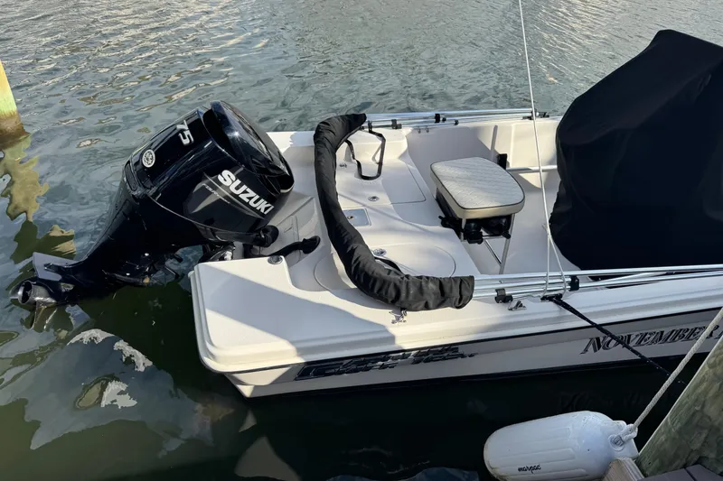 Slide: The Image of 2023 Carolina Skiff 16 JVX CC boat with Suzuki outboard motor docked in water. - 3