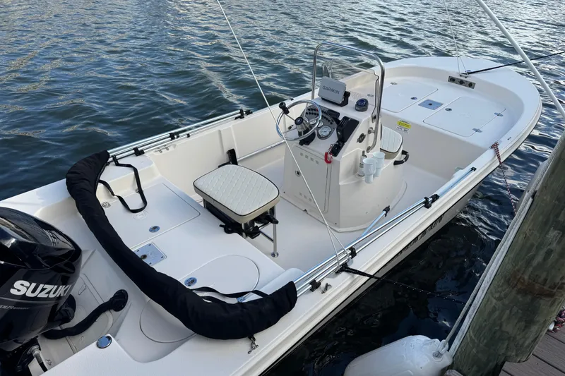 Slide: The Image of 2023 Carolina Skiff 16 JVX CC boat docked on water, featuring a Suzuki outboard motor. - 8