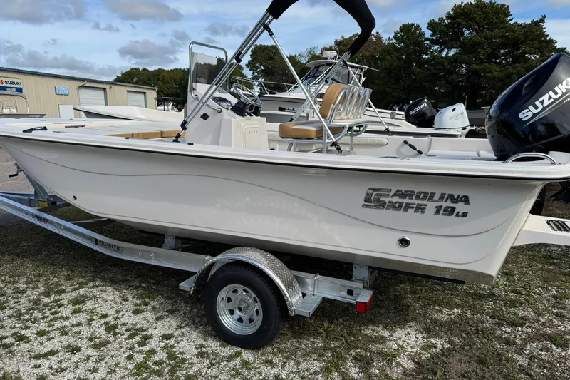 The Image of 2026 Carolina Skiff 19 LS boat on trailer, featuring Suzuki outboard motor. - 0