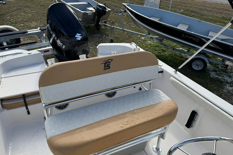 Slide: The Image of 2026 Carolina Skiff 19 LS boat interior with tan and white seating, Suzuki outboard motor. - 13