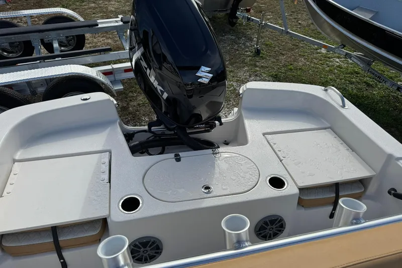 Slide: The Image of 2026 Carolina Skiff 19 LS boat with Suzuki outboard motor, featuring storage compartments. - 14