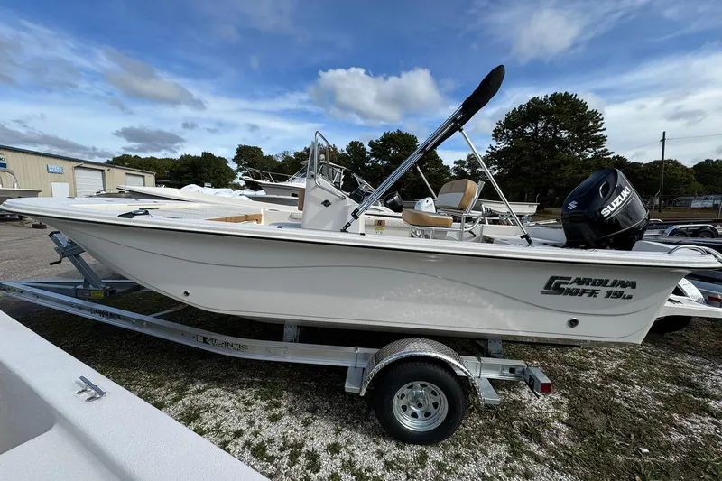 Slide: The Image of 2026 Carolina Skiff 19 LS boat on trailer, featuring Suzuki outboard motor. - 2