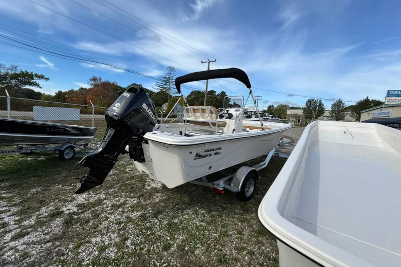 Slide: The Image of 2026 Carolina Skiff 19 LS boat with Suzuki outboard motor on trailer, outdoor display. - 6