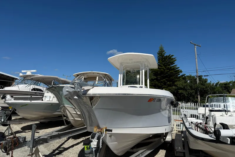 Slide: The Image of 2019 Robalo R242 Center Console boat on trailer under clear blue sky. - 0