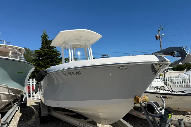Slide: The Image of 2019 Robalo R242 Center Console boat on trailer under clear blue sky. - 1