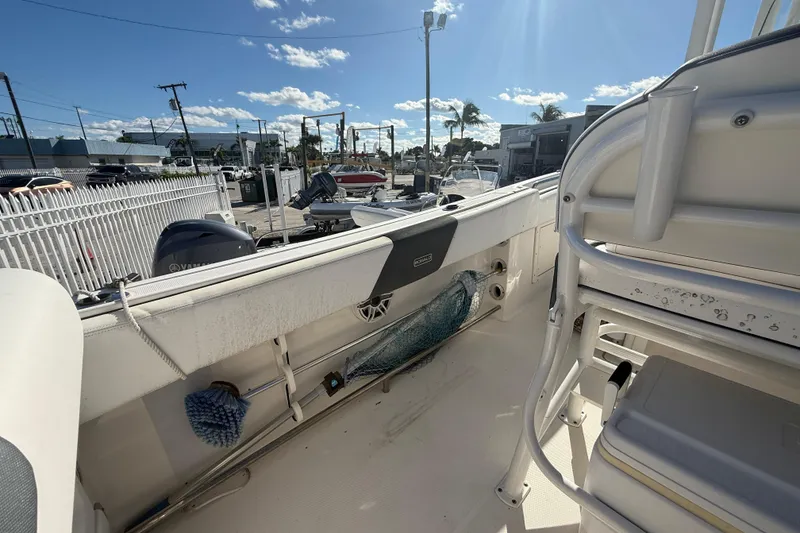 Slide: The Image of 2019 Robalo R242 Center Console boat interior with seating and storage, parked outdoors. - 10
