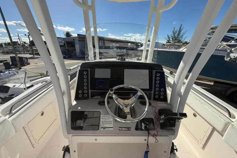Slide: The Image of 2019 Robalo R242 Center Console boat dashboard with steering wheel and navigation controls. - 11