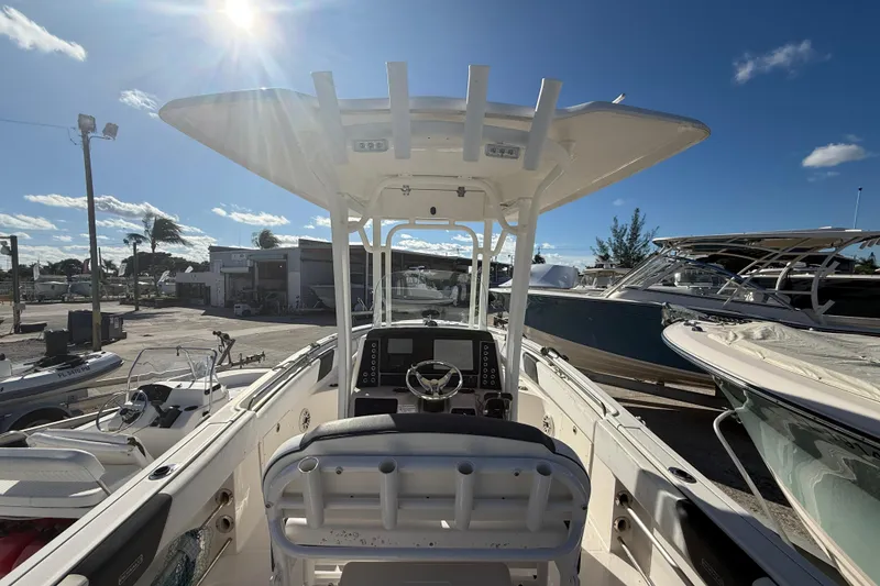 Slide: The Image of 2019 Robalo R242 Center Console boat in a sunny marina setting. - 12