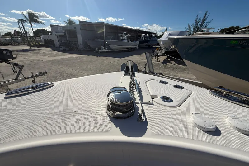 Slide: The Image of 2019 Robalo R242 Center Console boat deck with anchor, docked in a sunny marina. - 18