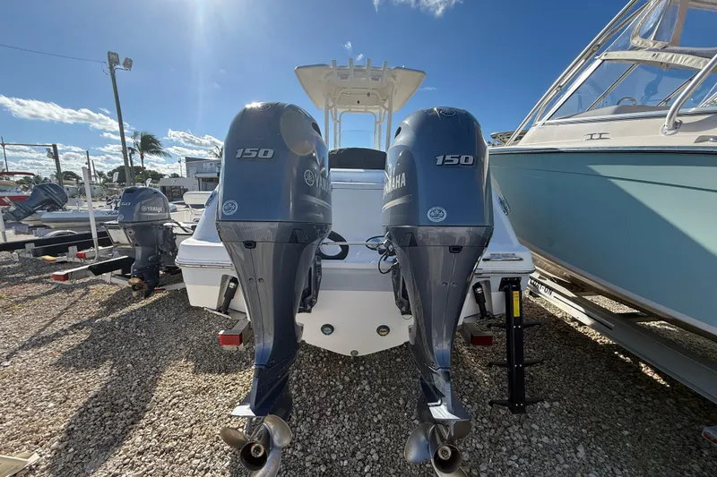 Slide: The Image of 2019 Robalo R242 Center Console with twin Yamaha 150 engines, parked on gravel. - 21