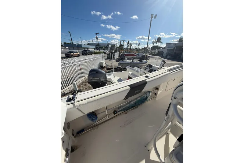 Slide: The Image of 2019 Robalo R242 Center Console boat with Yamaha engine, parked outdoors under clear sky. - 4