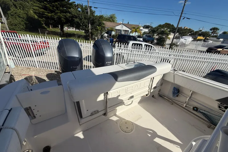 Slide: The Image of 2019 Robalo R242 Center Console boat with dual 150 horsepower engines, parked near a white fence. - 6