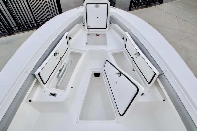 Slide: The Image of 2026 Regulator 25 boat with open storage compartments on deck. - 17