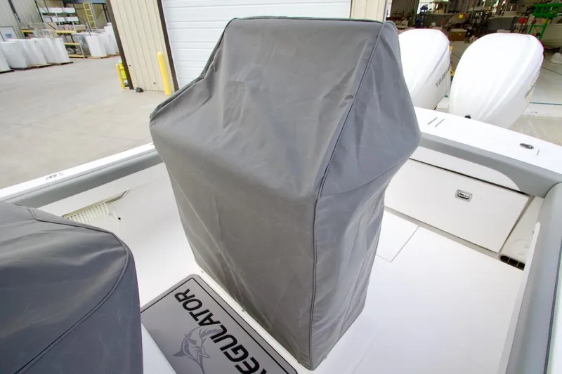 Slide: The Image of 2026 Regulator 25 boat with covered console, docked in a marina. - 18