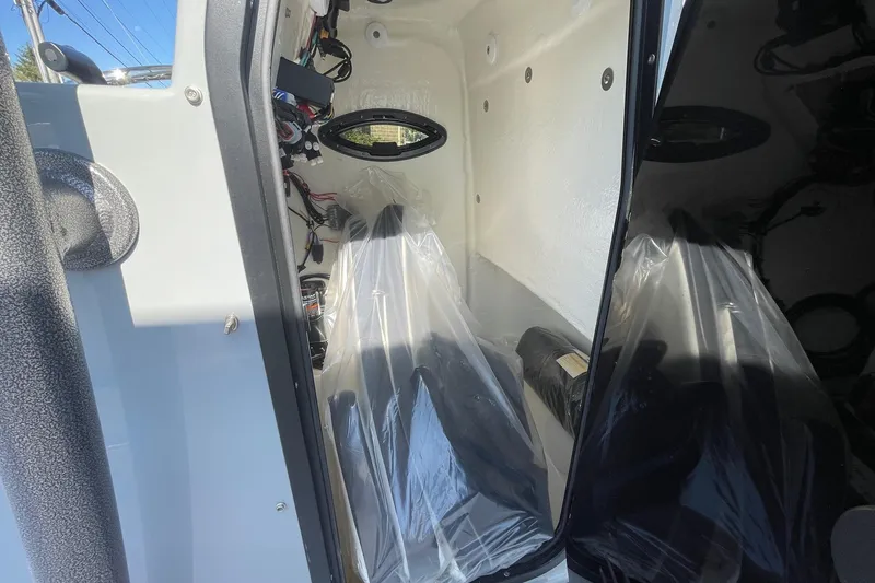 Slide: The Image of 2025 Sea Pro 222 Center Console interior with plastic-covered seats and visible wiring. - 29