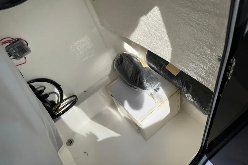 Slide: The Image of 2025 Sea Pro 222 Center Console storage compartment with equipment and wiring. - 32