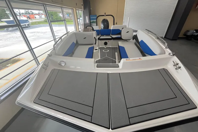 Slide: The Image of 2026 Starcraft SV 16 OB boat interior with blue and gray seating in showroom. - 10