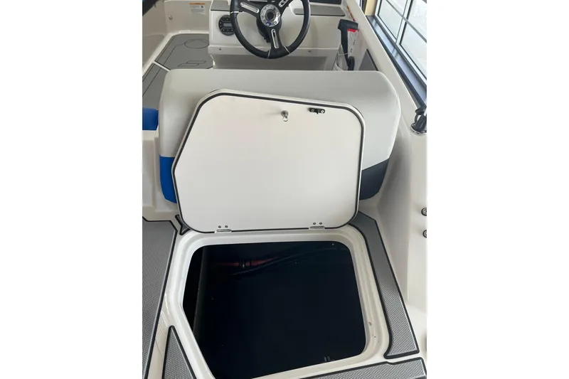 Slide: The Image of 2026 Starcraft SV 16 OB boat interior with open storage compartment and steering wheel. - 18