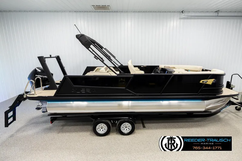 Slide: The Image of 2026 Alera M23L pontoon boat in showroom, featuring sleek black design and Mercury engine. - 1