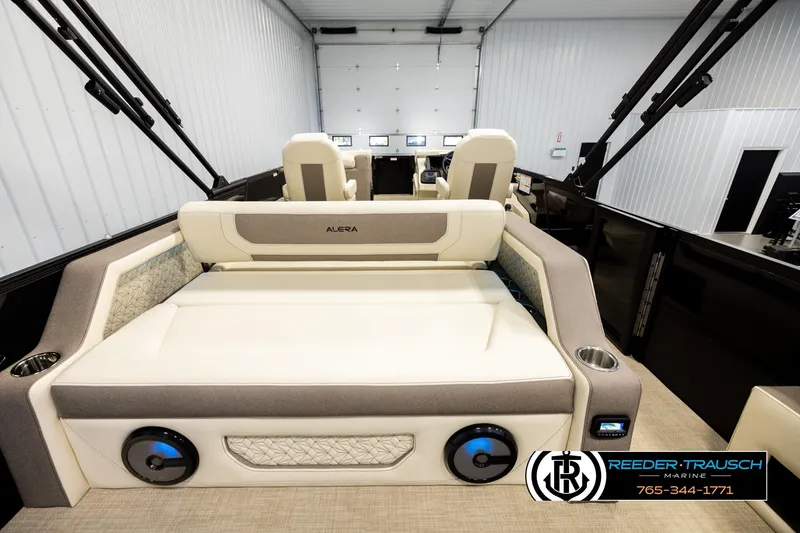 Slide: The Image of 2026 Alera M23L boat interior with plush seating in a showroom. - 16