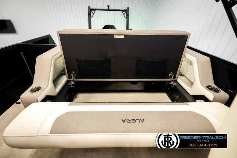 Slide: The Image of 2026 Alera M23L boat interior with open storage compartment and beige seating. - 22