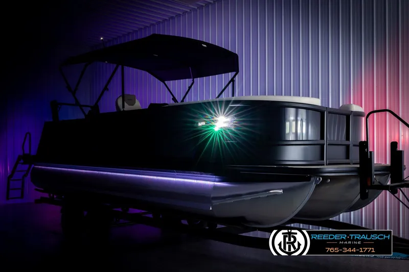 Slide: The Image of 2026 Alera M23L pontoon boat with illuminated deck in showroom. - 4