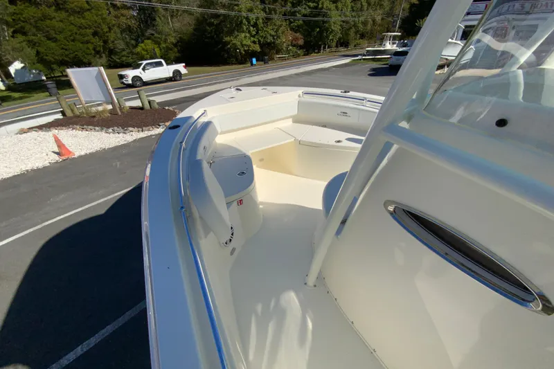 Slide: The Image of 2026 Cobia 220 Center Console boat, parked outdoors, showcasing spacious deck and seating area. - 19