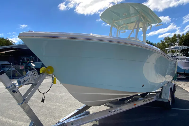 Slide: The Image of 2026 Cobia 220 Center Console boat on trailer under blue sky. - 4