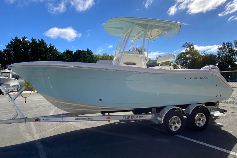 Slide: The Image of 2026 Cobia 220 Center Console boat on trailer under blue sky. - 5
