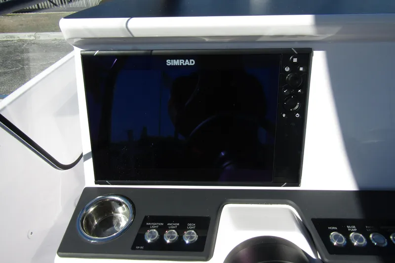 Slide: The Image of Control panel of 2024 Axopar 25 Cross Top with Simrad display and navigation controls. - 13