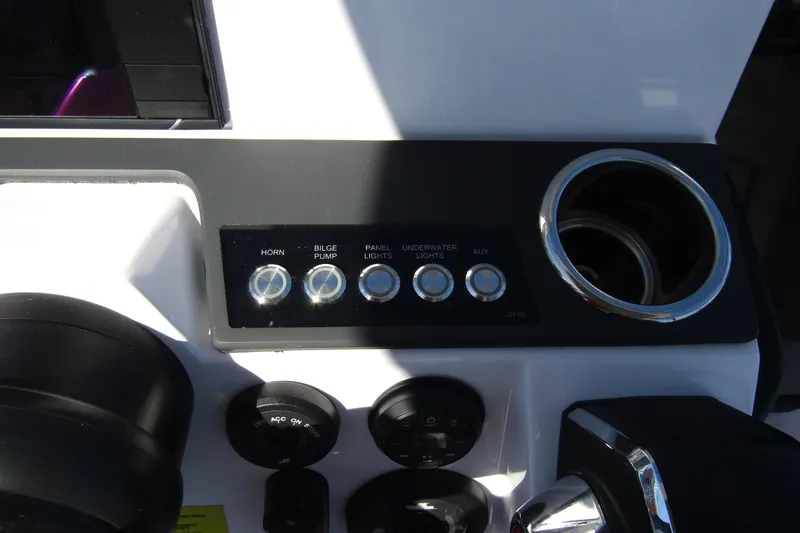 Slide: The Image of Control panel of 2024 Axopar 25 Cross Top boat with switches and cup holder. - 14