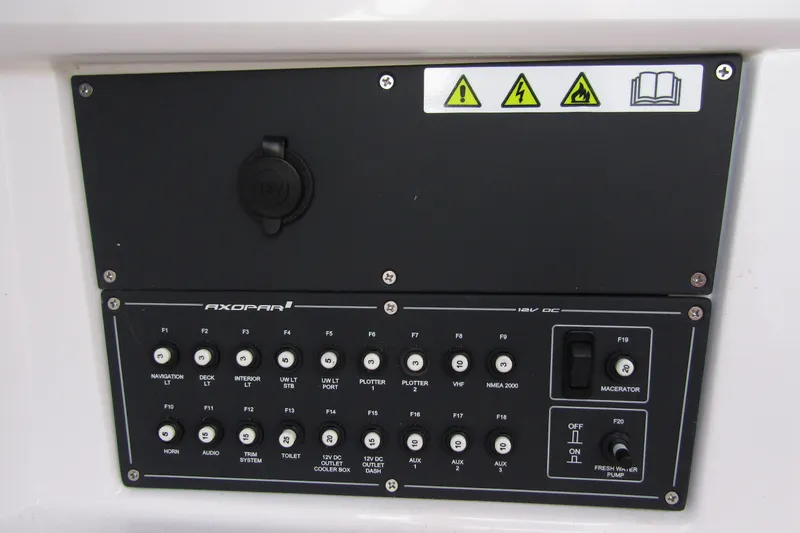 Slide: The Image of Control panel of 2024 Axopar 25 Cross Top boat with labeled switches and warnings. - 21