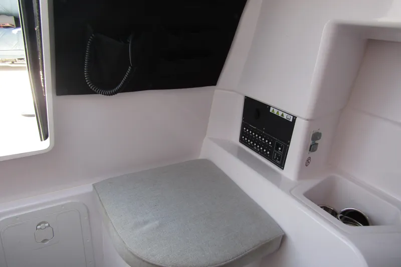 Slide: The Image of 2024 Axopar 25 Cross Top interior with control panel and cushioned seat. - 22