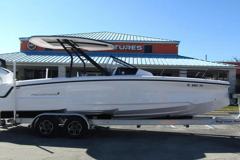 Slide: The Image of 2024 Axopar 25 Cross Top boat on trailer, parked outside a dealership. - 4