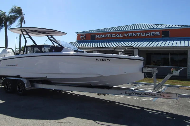 Slide: The Image of 2024 Axopar 25 Cross Top boat on trailer outside Nautical Ventures store. - 5