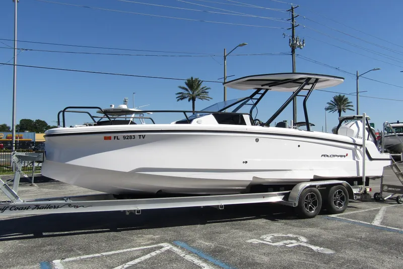 Slide: The Image of 2024 Axopar 25 Cross Top boat on trailer, parked outdoors under clear sky. - 6