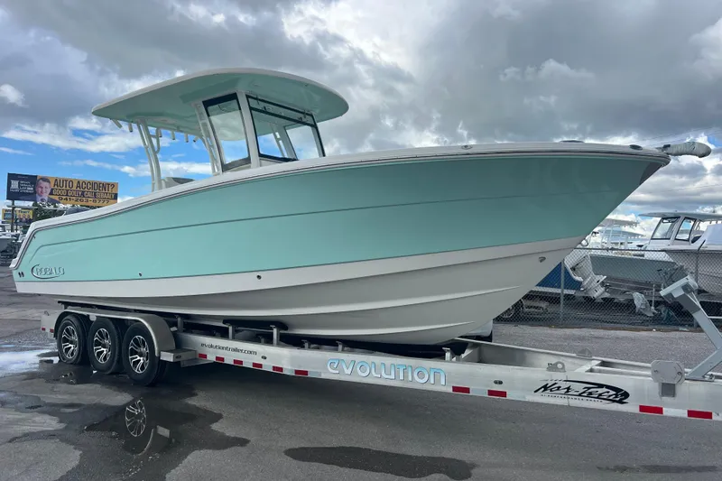 The Image of 2020 Robalo R302 Center Console boat on trailer under cloudy sky. - 0