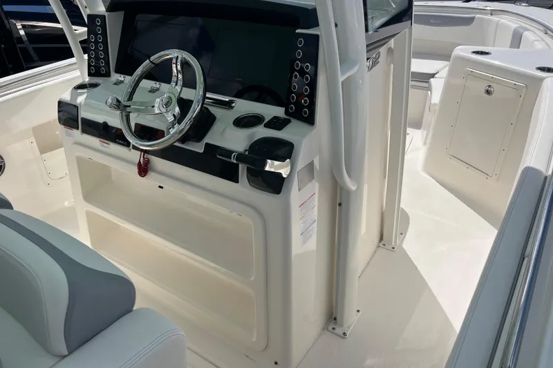 Slide: The Image of 2020 Robalo R302 Center Console boat interior with steering wheel and control panel. - 11
