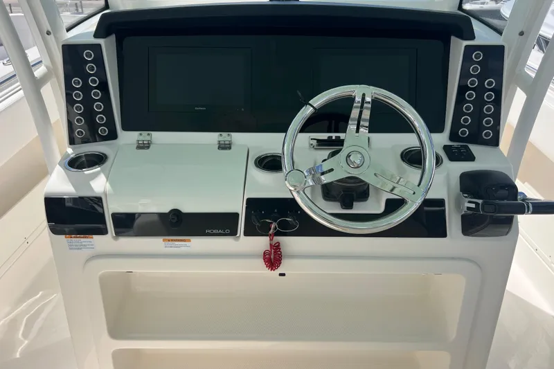 Slide: The Image of 2020 Robalo R302 Center Console helm with steering wheel and control panel. - 12