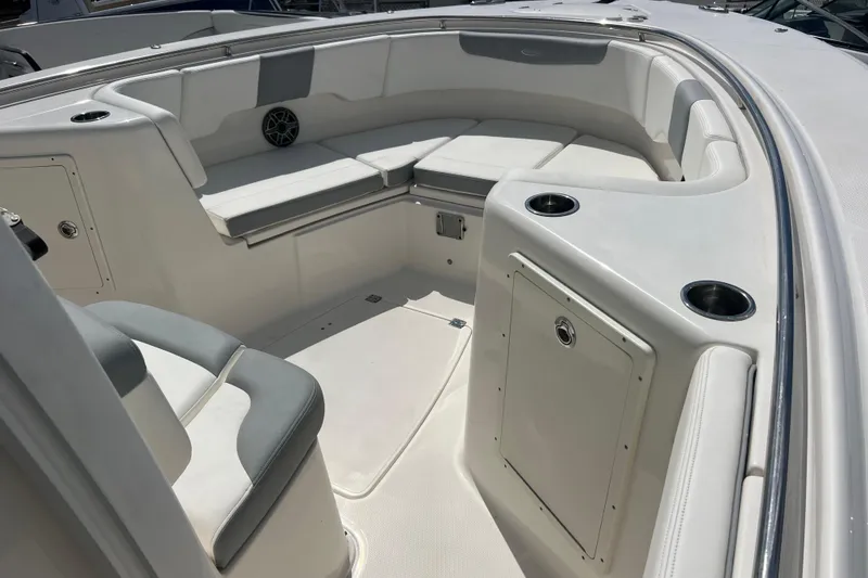 Slide: The Image of 2020 Robalo R302 Center Console boat interior with cushioned seating and cup holders. - 14