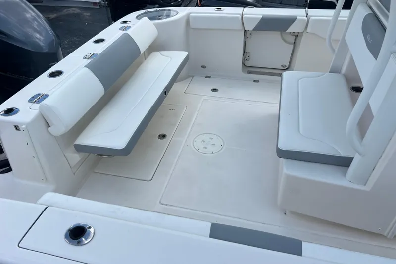 Slide: The Image of 2020 Robalo R302 Center Console boat interior with white seating and cup holders. - 18