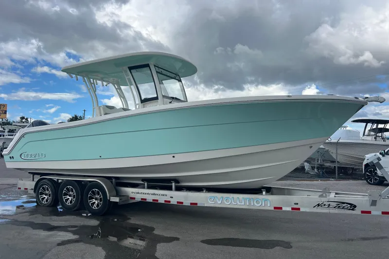 Slide: The Image of 2020 Robalo R302 Center Console boat on trailer under cloudy sky. - 2