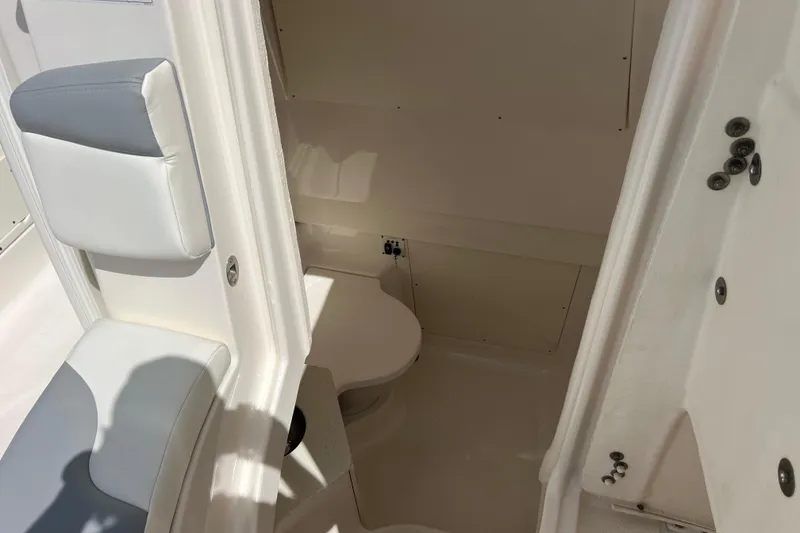Slide: The Image of 2020 Robalo R302 Center Console boat interior with seating and toilet. - 20