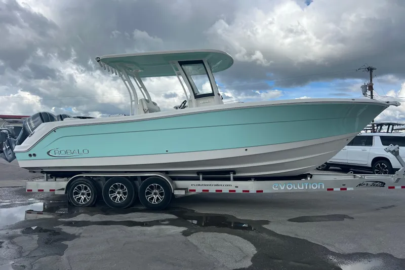 Slide: The Image of 2020 Robalo R302 Center Console boat on trailer under cloudy sky. - 3