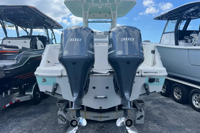 Slide: The Image of 2020 Robalo R302 Center Console with dual Yamaha 300 engines, docked under blue sky. - 5
