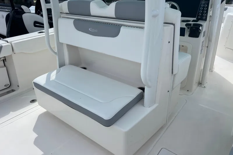 Slide: The Image of 2020 Robalo R302 Center Console boat interior with white seating and control panel. - 9